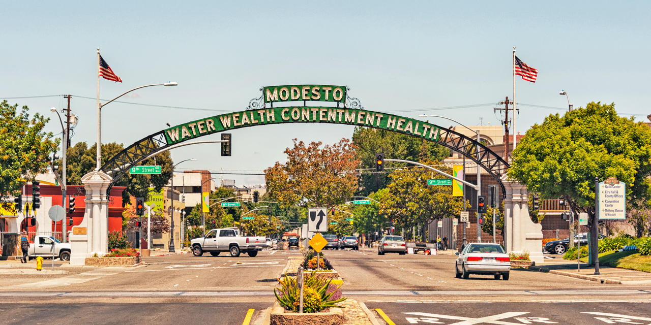 The Modesto arch reading Water Wealth Contentment Health over 9th Street